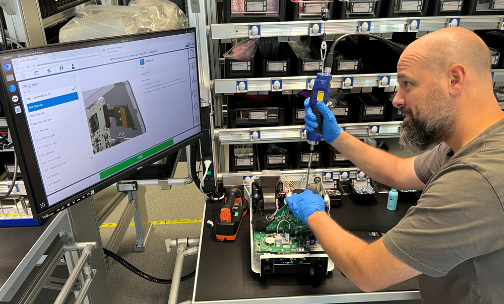 The production control system displays the individual assembly steps on screen in the specified sequence. Training production line box ventilator Buchs